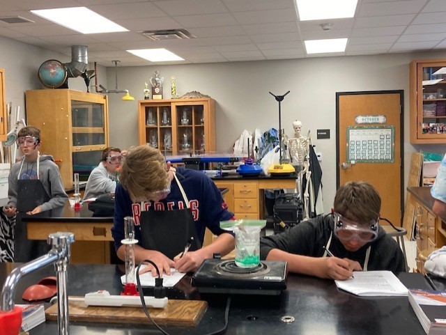 Austin  and Mason completing lab sheets about their plastic lab.
